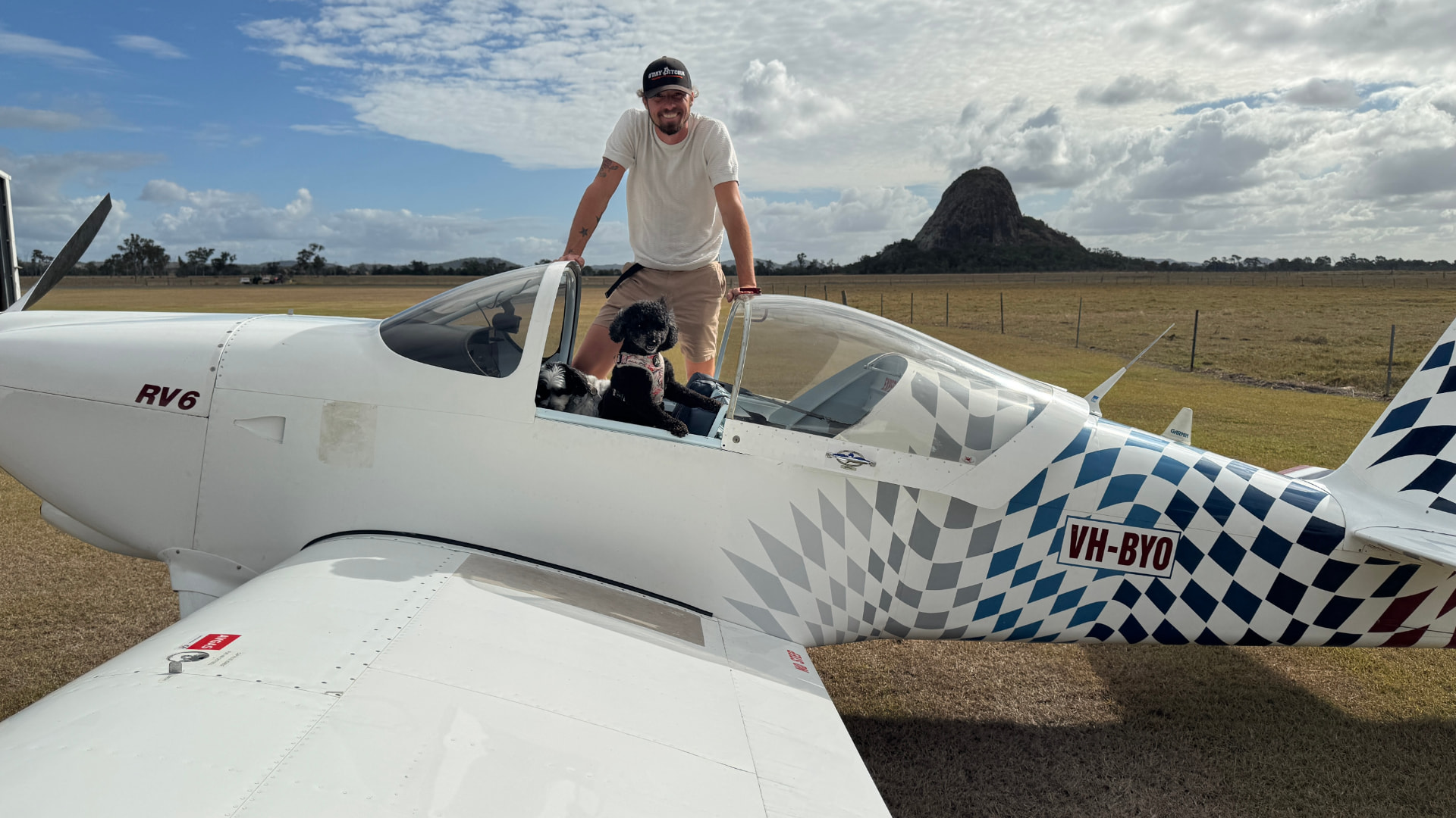 Sean with his dogs beside his RV6 plane on a grass airstrip in Queensland